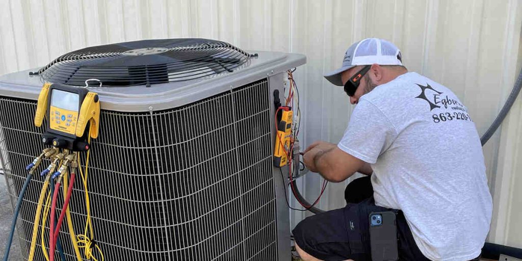 Technician repairing an outdoor air conditioning unit