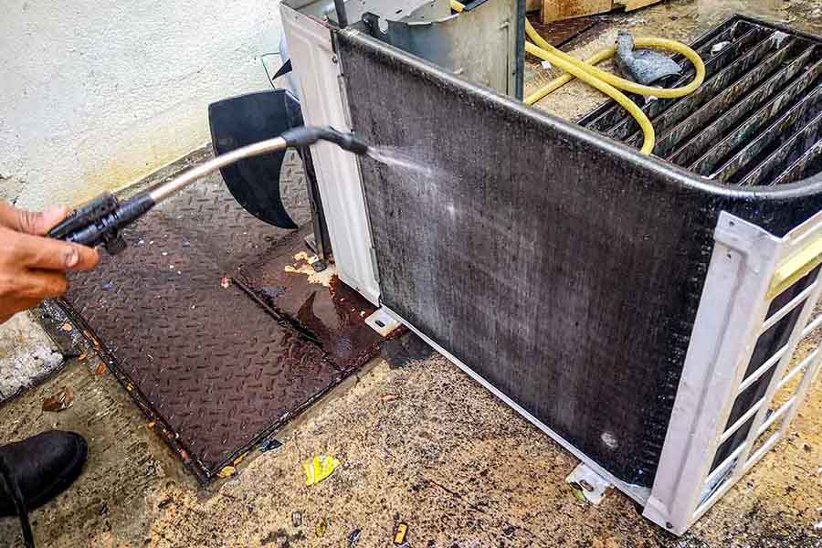 Technician performing AC coil cleaning