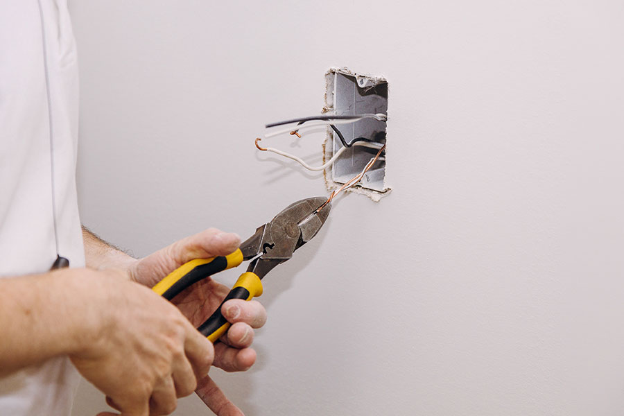 Electrician performing outlet repair & installation